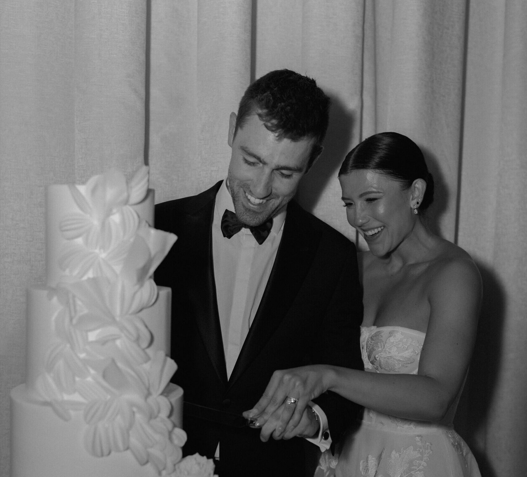 wedding couple cutting wedding cake and smiling